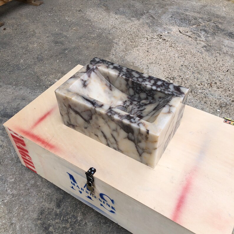 Calacatta Viola marble wall-mount sink with stunning natural veining. Handcrafted floating stone basin with no overflow, single faucet hole. Perfect for luxury bathrooms, interior designers, boutique hotels, and modern renovations. Ideal as a vessel sink, bar sink, or designer washbasin. Unique Italian marble sink for minimalist, high-end bathrooms. Trending marble bathroom decor, handcrafted stone sink.