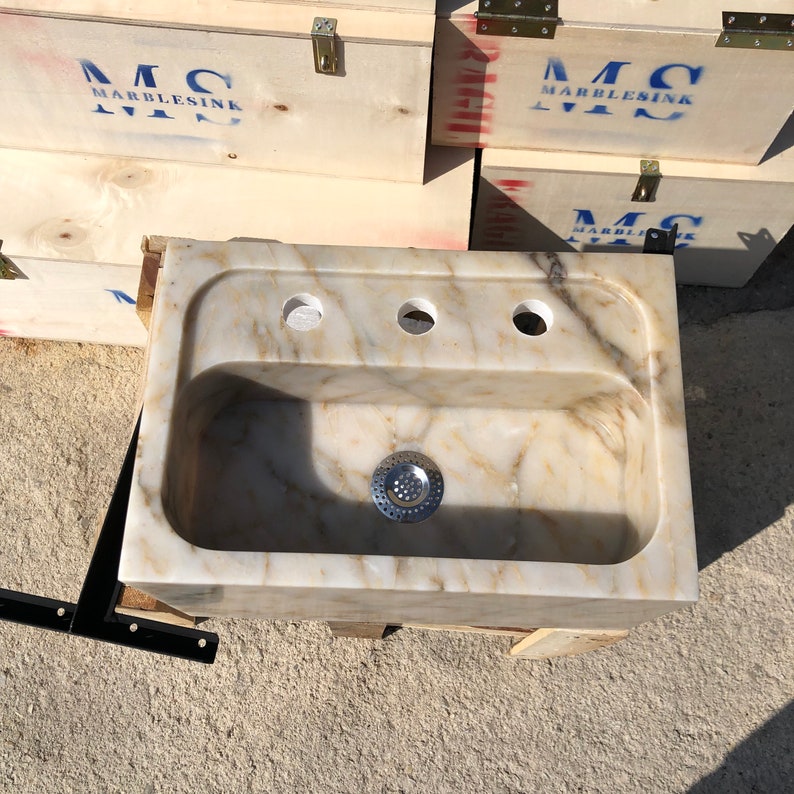 Direct overhead view of a rectangular Calacatta Viola marble bathroom sink with a deep rounded bowl, centered drain, three faucet holes and natural cream, gold and grey stone veining.