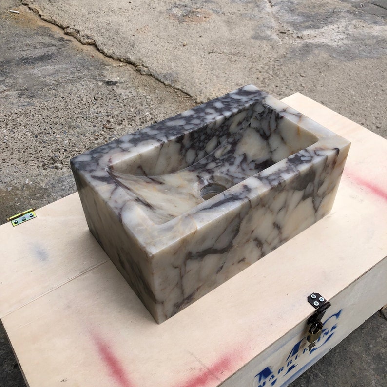 Calacatta Viola marble wall-mount sink with stunning natural veining. Handcrafted floating stone basin with no overflow, single faucet hole. Perfect for luxury bathrooms, interior designers, boutique hotels, and modern renovations. Ideal as a vessel sink, bar sink, or designer washbasin. Unique Italian marble sink for minimalist, high-end bathrooms. Trending marble bathroom decor, handcrafted stone sink.