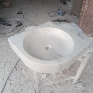 "Hand-carved Carrara marble sink – elegant, durable, and timeless. Perfect for luxury bathrooms, powder rooms, and boutique interiors. Custom sizes available: wall-mounted or countertop installation. Each piece features unique natural veining, adding character to your space. Discover our full collection of marble sinks, bathtubs, and stone accessories at MarbleSinkCo – follow us for more exclusive designs."