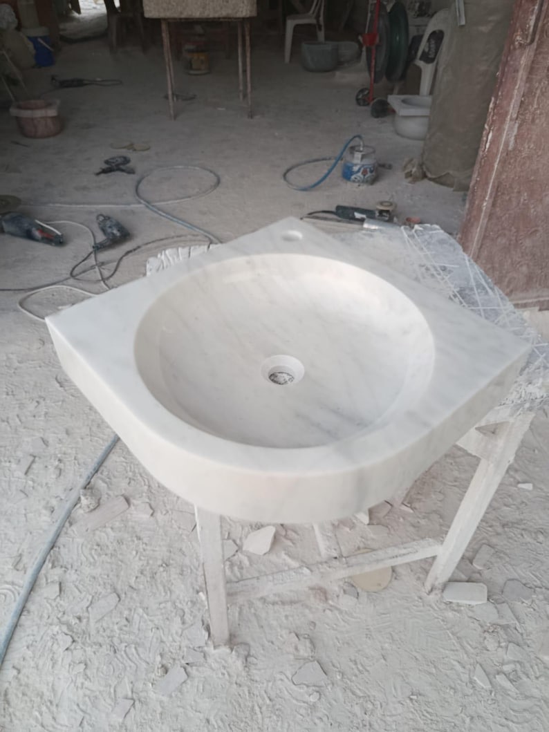 "Hand-carved Carrara marble sink – elegant, durable, and timeless. Perfect for luxury bathrooms, powder rooms, and boutique interiors. Custom sizes available: wall-mounted or countertop installation. Each piece features unique natural veining, adding character to your space. Discover our full collection of marble sinks, bathtubs, and stone accessories at MarbleSinkCo – follow us for more exclusive designs."