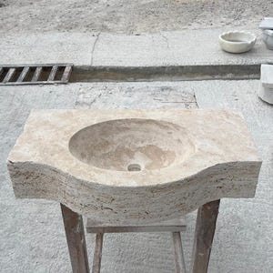 Hand-carved rectangular beige travertine countertop vessel sink with a smooth honed basin, rough chiseled exterior, centered drain and single faucet hole, custom-size natural stone bathroom washbasin by MarbleSinkCo.
