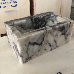 Calacatta Viola marble wall-mount sink with stunning natural veining. Handcrafted floating stone basin with no overflow, single faucet hole. Perfect for luxury bathrooms, interior designers, boutique hotels, and modern renovations. Ideal as a vessel sink, bar sink, or designer washbasin. Unique Italian marble sink for minimalist, high-end bathrooms. Trending marble bathroom decor, handcrafted stone sink.