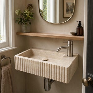 Small wall-mounted Light Travertine basin installed in a modern compact powder room
