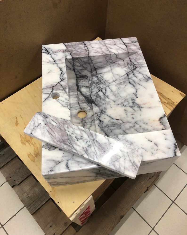 natural-stone-sink-collection.jpg MarbleSinkCo natural stone collection with labeled Carrara, Calacatta, Lilac, Travertine and Nero Marquina samples.