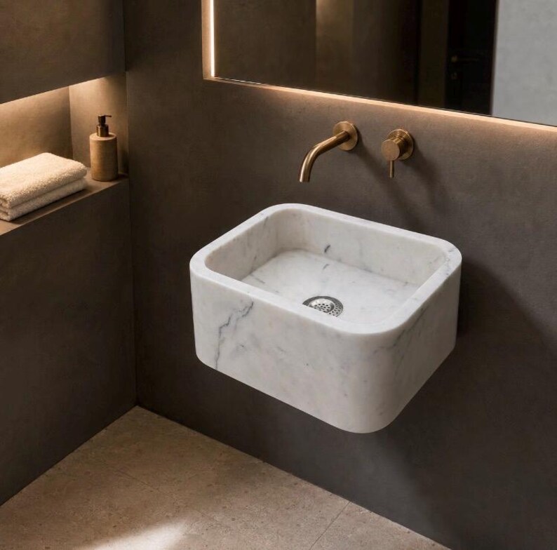 Carrara White marble sink wall mounted in a modern luxury bathroom with rounded rectangular basin and grey veining