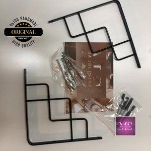Puede incluir: Dos soportes de estanter&iacute;a de metal negro con un dise&ntilde;o geom&eacute;trico. Los soportes se empaquetan con tornillos para la instalaci&oacute;n. El embalaje incluye el texto "Marble Sink".