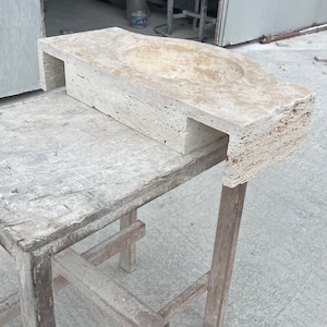 Hand-carved rectangular beige travertine countertop vessel sink with a smooth honed basin, rough chiseled exterior, centered drain and single faucet hole, custom-size natural stone bathroom washbasin by MarbleSinkCo.