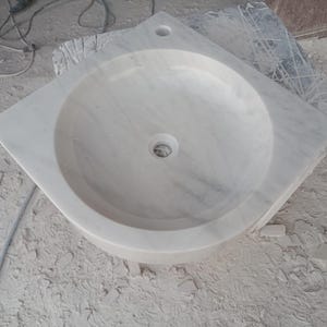 "Hand-carved Carrara marble sink – elegant, durable, and timeless. Perfect for luxury bathrooms, powder rooms, and boutique interiors. Custom sizes available: wall-mounted or countertop installation. Each piece features unique natural veining, adding character to your space. Discover our full collection of marble sinks, bathtubs, and stone accessories at MarbleSinkCo – follow us for more exclusive designs."