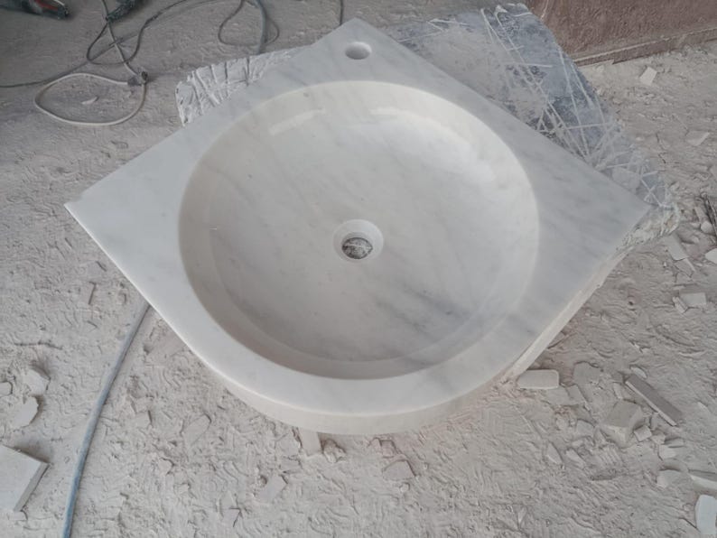"Hand-carved Carrara marble sink – elegant, durable, and timeless. Perfect for luxury bathrooms, powder rooms, and boutique interiors. Custom sizes available: wall-mounted or countertop installation. Each piece features unique natural veining, adding character to your space. Discover our full collection of marble sinks, bathtubs, and stone accessories at MarbleSinkCo – follow us for more exclusive designs."