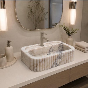 calacatta viola marble sink, fluted marble sink, grooved marble sink, wall mounted marble sink, wall hung stone basin, small powder room sink, compact bathroom sink, luxury powder room vanity, handcrafted marble basin, natural stone bathroom sink, custom marble sink, purple marble sink, burgundy marble sink, floating marble vanity, designer bathroom sink, boutique hotel bathroom sink, narrow bathroom sink, handmade stone sink, marble washbasin, architectural bathroom sink
