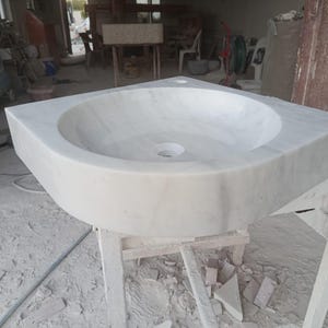 "Hand-carved Carrara marble sink – elegant, durable, and timeless. Perfect for luxury bathrooms, powder rooms, and boutique interiors. Custom sizes available: wall-mounted or countertop installation. Each piece features unique natural veining, adding character to your space. Discover our full collection of marble sinks, bathtubs, and stone accessories at MarbleSinkCo – follow us for more exclusive designs."