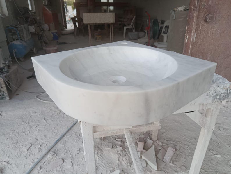 "Hand-carved Carrara marble sink – elegant, durable, and timeless. Perfect for luxury bathrooms, powder rooms, and boutique interiors. Custom sizes available: wall-mounted or countertop installation. Each piece features unique natural veining, adding character to your space. Discover our full collection of marble sinks, bathtubs, and stone accessories at MarbleSinkCo – follow us for more exclusive designs."