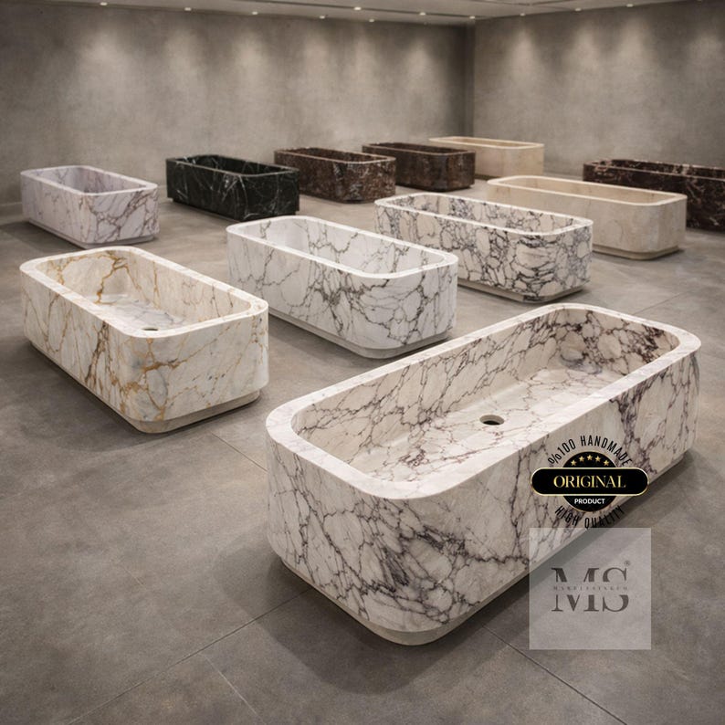 May include: A collection of rectangular marble bathtubs in various colors, including white, black, brown, and beige. The tubs have rounded edges and a smooth finish. Some tubs feature a swirling vein pattern. The image includes a logo that says "Original Product".