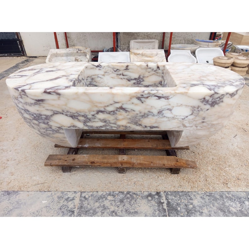 Suspended marble sink made from rare Calacatta Viola marble, floating vanity basin carved by master artisans, luxury architectural statement sink designed for high end bathrooms, sculptural stone sink suspended with ceiling chains creating a dramatic floating illusion, custom luxury marble sink perfect for designer interiors and iconic architectural spaces