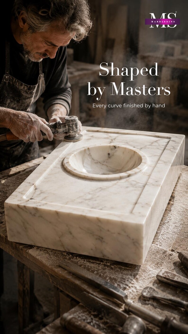 Raw Calacatta Gold marble block extracted from a quarry, showing natural white stone with gray and golden veining before becoming a handmade marble sink