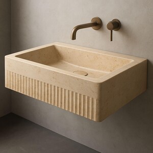 Handmade travertine wall-mounted sink with fluted front and matte finish. Custom sizes available. Ideal for luxury bathrooms, hotels, interior designers, and modern spa spaces. Each basin is carved from solid stone. Ships globally in a wooden crate via DHL Express. Natural veining varies uniquely in each piece.Perfect for minimalist,rustic,and architectural interiors, travertine wall-mounted sink,fluted front, solid stone, custom sizes,interior designers, modern spa, luxury bathrooms, minimalist