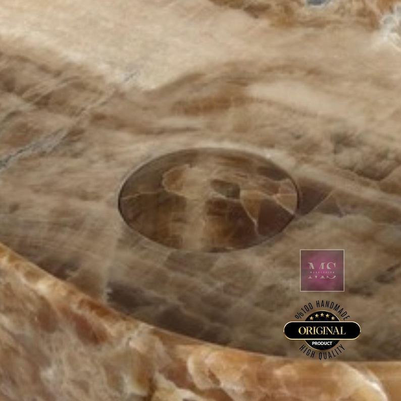 Puede incluir: Primer plano de un lavabo de &oacute;nix marr&oacute;n y beige con un agujero de drenaje. El lavabo est&aacute; hecho a mano y tiene un acabado de alta calidad.