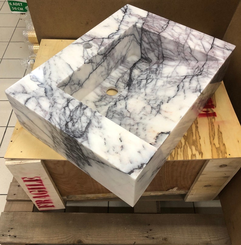 marblesinkco-carrara-sink-workshop.jpg Carrara marble sink resting on a workshop table during final inspection at the MarbleSinkCo stone atelier in Türkiye.
