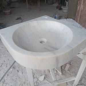 "Hand-carved Carrara marble sink – elegant, durable, and timeless. Perfect for luxury bathrooms, powder rooms, and boutique interiors. Custom sizes available: wall-mounted or countertop installation. Each piece features unique natural veining, adding character to your space. Discover our full collection of marble sinks, bathtubs, and stone accessories at MarbleSinkCo – follow us for more exclusive designs."