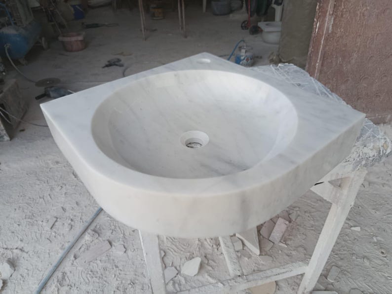 "Hand-carved Carrara marble sink – elegant, durable, and timeless. Perfect for luxury bathrooms, powder rooms, and boutique interiors. Custom sizes available: wall-mounted or countertop installation. Each piece features unique natural veining, adding character to your space. Discover our full collection of marble sinks, bathtubs, and stone accessories at MarbleSinkCo – follow us for more exclusive designs."