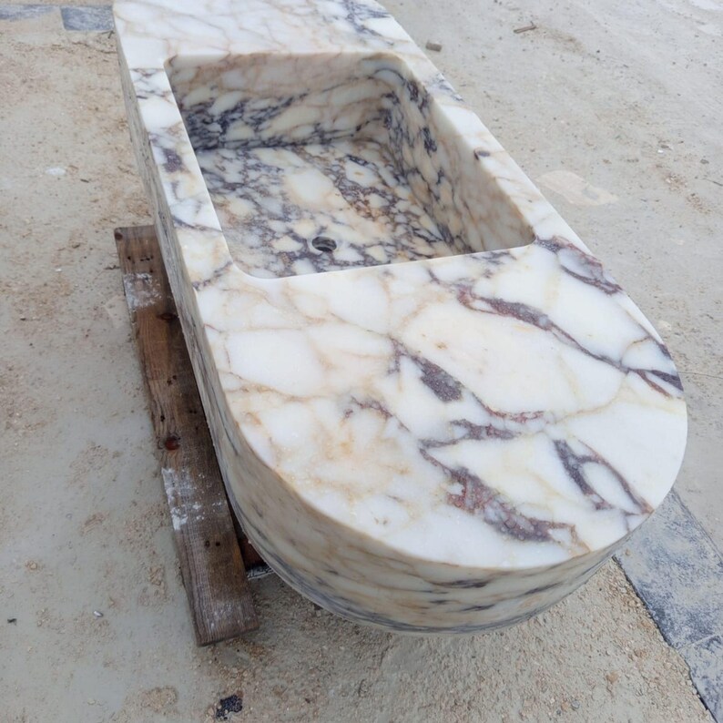 Luxury floating marble sink handcrafted from rare Calacatta Viola marble, suspended bathroom vanity basin designed for villas, penthouses and luxury homes, sculptural stone sink carved from a 2 ton marble block, architectural designer sink suspended with steel chains creating a stunning centerpiece for modern luxury bathrooms
