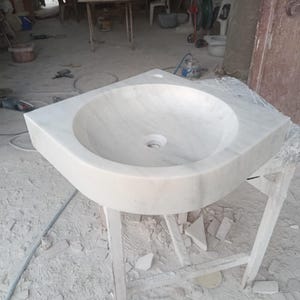 "Hand-carved Carrara marble sink – elegant, durable, and timeless. Perfect for luxury bathrooms, powder rooms, and boutique interiors. Custom sizes available: wall-mounted or countertop installation. Each piece features unique natural veining, adding character to your space. Discover our full collection of marble sinks, bathtubs, and stone accessories at MarbleSinkCo – follow us for more exclusive designs."