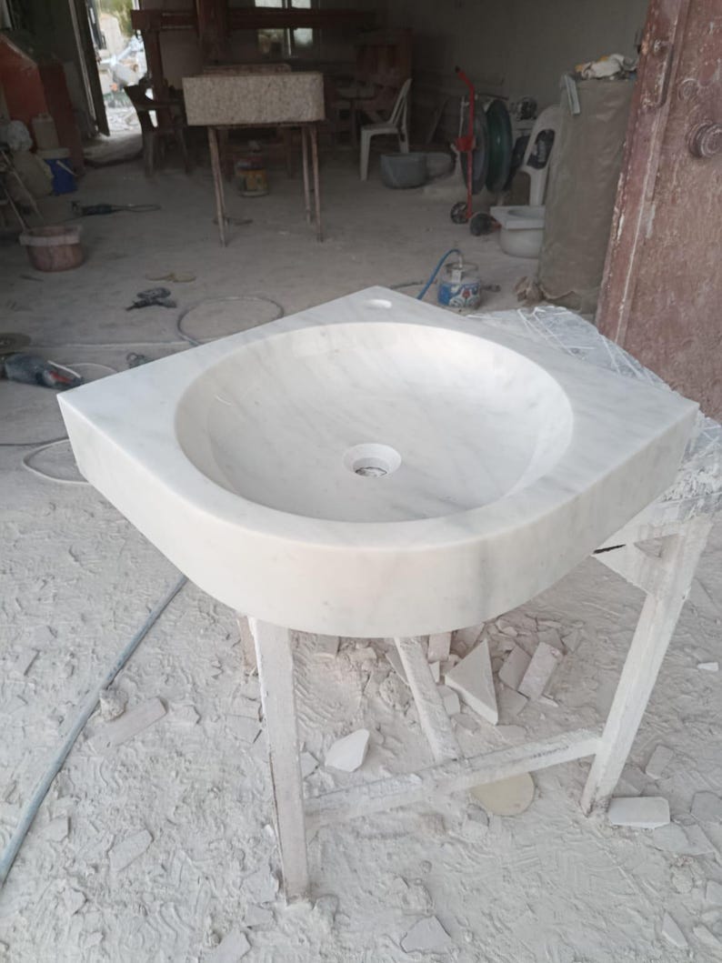 "Hand-carved Carrara marble sink – elegant, durable, and timeless. Perfect for luxury bathrooms, powder rooms, and boutique interiors. Custom sizes available: wall-mounted or countertop installation. Each piece features unique natural veining, adding character to your space. Discover our full collection of marble sinks, bathtubs, and stone accessories at MarbleSinkCo – follow us for more exclusive designs."