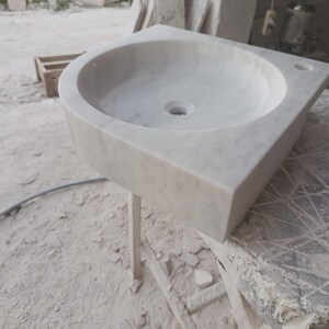 "Hand-carved Carrara marble sink – elegant, durable, and timeless. Perfect for luxury bathrooms, powder rooms, and boutique interiors. Custom sizes available: wall-mounted or countertop installation. Each piece features unique natural veining, adding character to your space. Discover our full collection of marble sinks, bathtubs, and stone accessories at MarbleSinkCo – follow us for more exclusive designs."