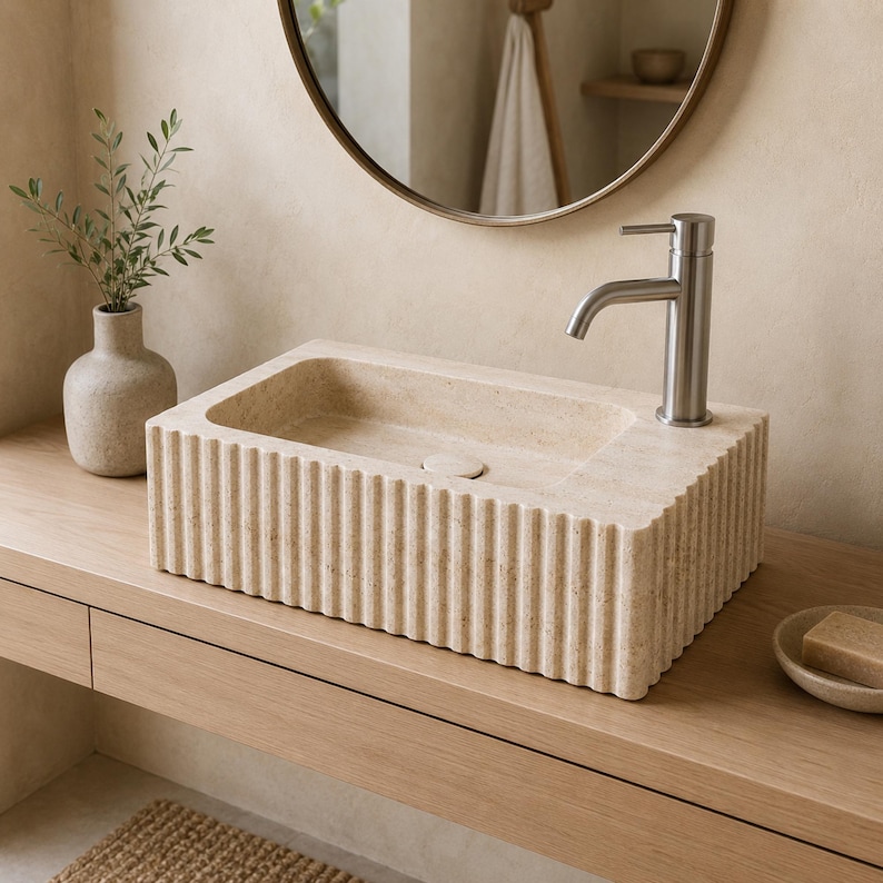 Light Travertine fluted basin used as a countertop sink with right-side single-hole faucet
