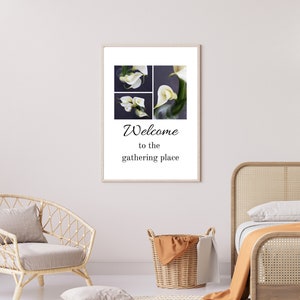 May include: A framed print featuring a collage of four white calla lilies against a dark backdrop. The text "Welcome to the gathering place" is printed beneath the images.