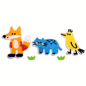 May include: Embroidered patches featuring a cartoon fox in orange and white, a blue cat with black spots, and a yellow bird with a black beak and feet. Small green grass accents are included.