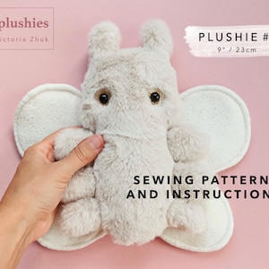 Puede incluir: Un patrón de costura para un peluche con forma de mariposa de 23 cm con un cuerpo marrón claro y ojos dorados. El patrón incluye instrucciones para coser el peluche.