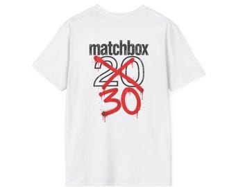 May include: A white short-sleeved t-shirt featuring the black text matchbox above the number 20 in black outline. A red spray-painted X crosses out the 20, with the number 30 written below in red spray-painted style lettering.