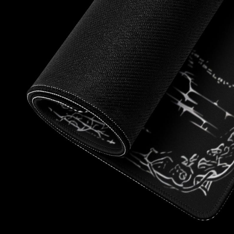 May include: Rolled-up black mouse pad with white stitched edges. The pad features a detailed white graphic design on the visible surface. The texture of the pad is visible, and the background is black.