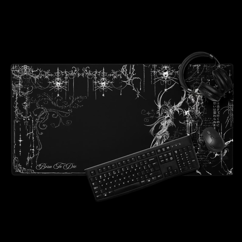 May include: Black gaming mouse pad with white decorative floral and gothic-style illustrations. The words "Born To Die" are printed on the pad. A black keyboard, mouse, and headphones are also visible.