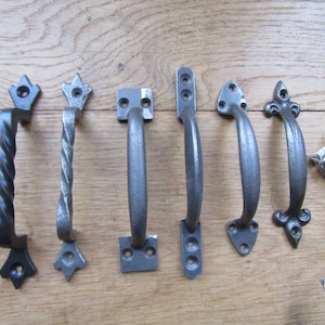 Può includere: Sette diversi stili di maniglie per porte nere e argentate. Le maniglie sono in metallo e hanno una varietà di design, tra cui un design a corda intrecciata, un design quadrato e un design appuntito.