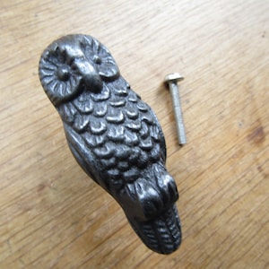 Peut inclure: Une poignée de porte en fonte d'un hibou de couleur gris foncé. La poignée présente un design détaillé de hibou avec une surface texturée. Elle est livrée avec une vis assortie.