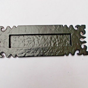 May include: Black metal letter plate with an ornate design. The plate has a rectangular opening for mail and comes with two screws for installation.