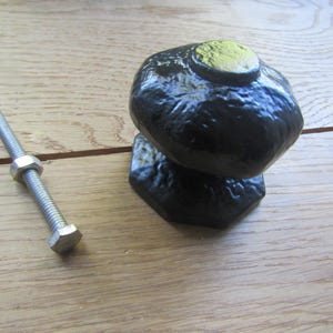 Pode incluir: Maçaneta de porta de ferro fundido preto com base hexagonal e parafuso e porca.