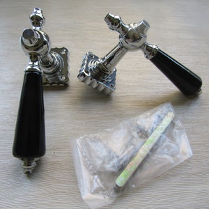 May include: Two chrome door handles with black ceramic knobs and square backplates. The handles are packaged with screws in a clear plastic bag.
