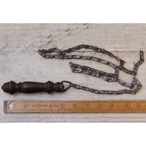 Puede incluir: Un mango de madera con una cadena metálica unida. La cadena está hecha de anillos metálicos unidos. El mango mide aproximadamente 12,7 cm de largo. La cadena mide aproximadamente 25,4 cm de largo.