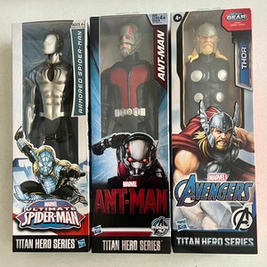 Pu&ograve; includere: Tre scatole di action figure con personaggi Marvel. Le scatole presentano "ARMORED SPIDER-MAN", "ANT-MAN" e "THOR". Ogni personaggio fa parte della "TITAN HERO SERIES" ed &egrave; consigliato per bambini dai 4 anni in su. Il logo "AVENGERS" &egrave; visibile.