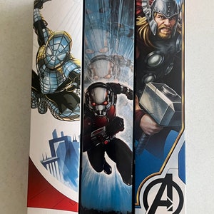 Pu&ograve; includere: Tre scatole di action figure della serie Titan Hero con personaggi Marvel. Le scatole mostrano Spider-Man, Ant-Man e Thor degli Avengers. Ogni scatola ha una diversa combinazione di colori e illustrazione del personaggio.
