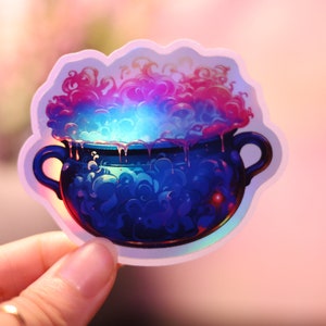 May include: A sticker featuring a blue cauldron with a bubbling, colorful potion. The potion is a mix of pink, purple, and blue, with a glowing effect. The cauldron has two handles and is dripping with liquid. The sticker has a holographic effect.