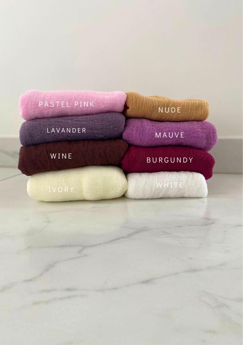 May include: A stack of eight fabric squares in different colors, including pastel pink, lavender, wine, ivory, white, burgundy, mauve, and nude. The fabric squares are arranged from lightest to darkest.