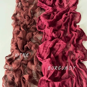 May include: Two pieces of fabric, one in a wine color and the other in burgundy. The fabric is soft and crinkled, with a textured surface. The fabric is labeled "WINE" and "BURGUNDY".