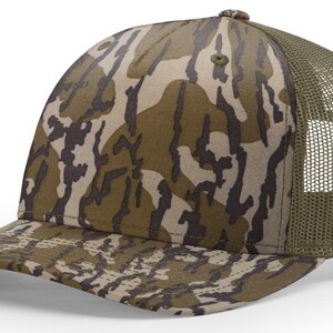 May include: A camouflage baseball cap with a curved brim and a mesh back. The cap features a pattern of brown, tan, and olive green shapes. The mesh back is olive green.