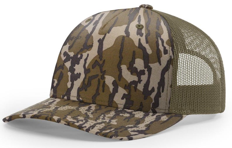 May include: A camouflage baseball cap with a curved brim and a mesh back. The cap features a pattern of brown, tan, and olive green shapes. The mesh back is olive green.