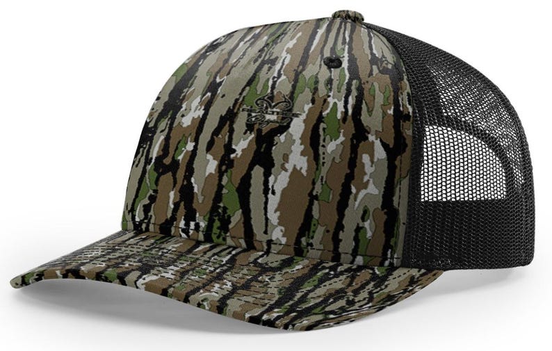 May include: A camouflage baseball cap with a black mesh back. The cap features a pattern of green, brown, and white, with a small logo on the front. The brim is curved and the cap has a button on top.